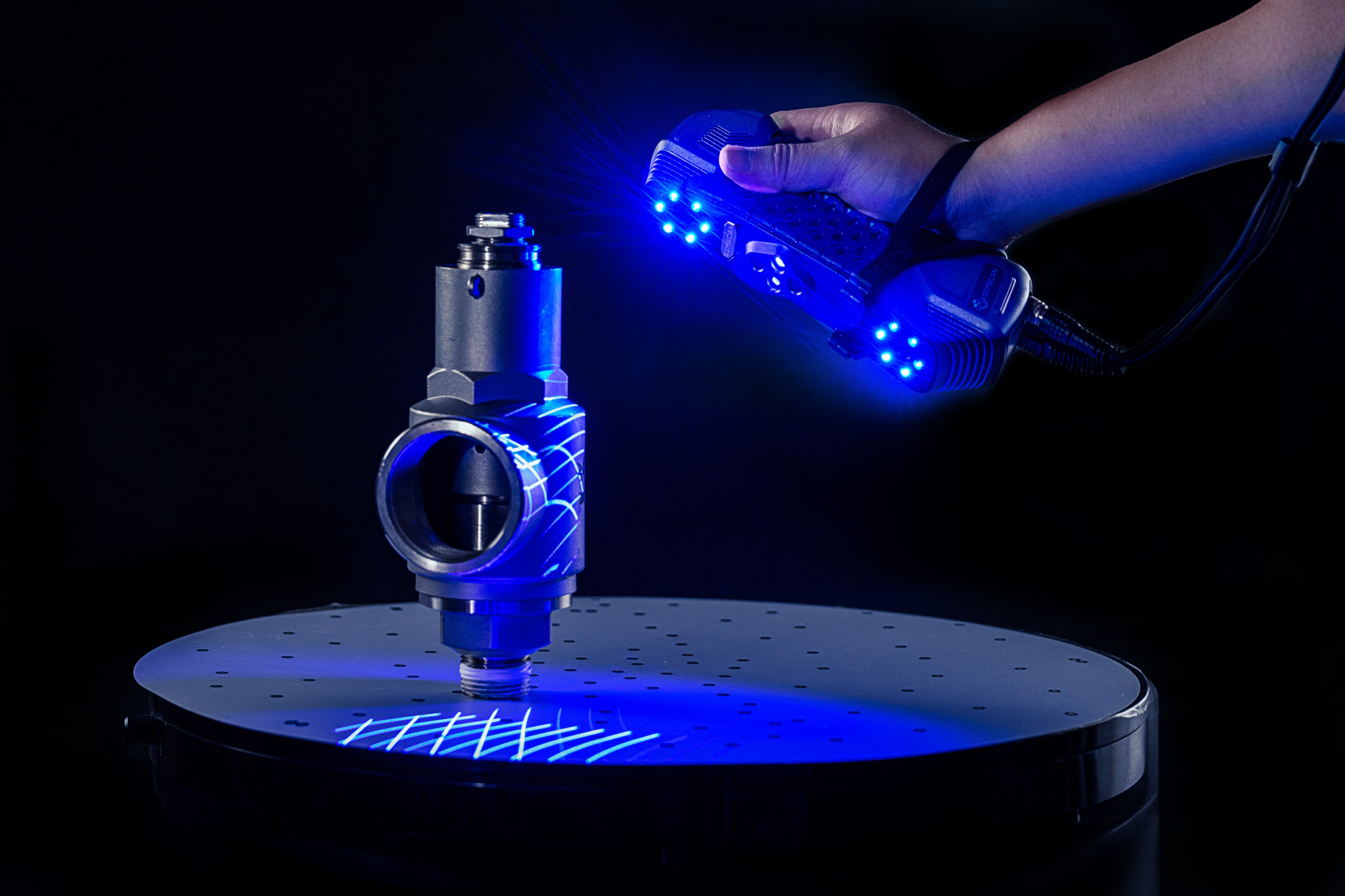 A stainless valve being 3D-scanned under blue light
